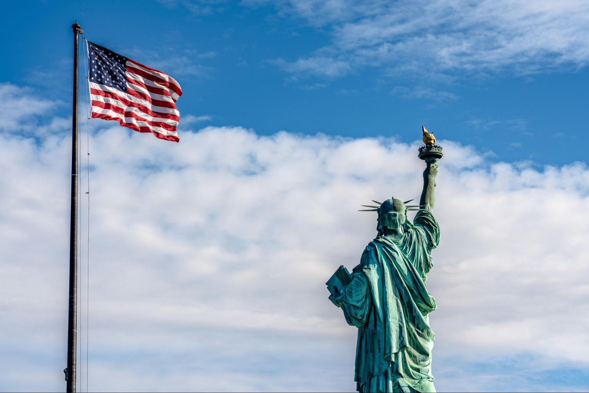 View of the United States flag and the Statue of Liberty on Liberty Island on October 10, 2019 in New York
