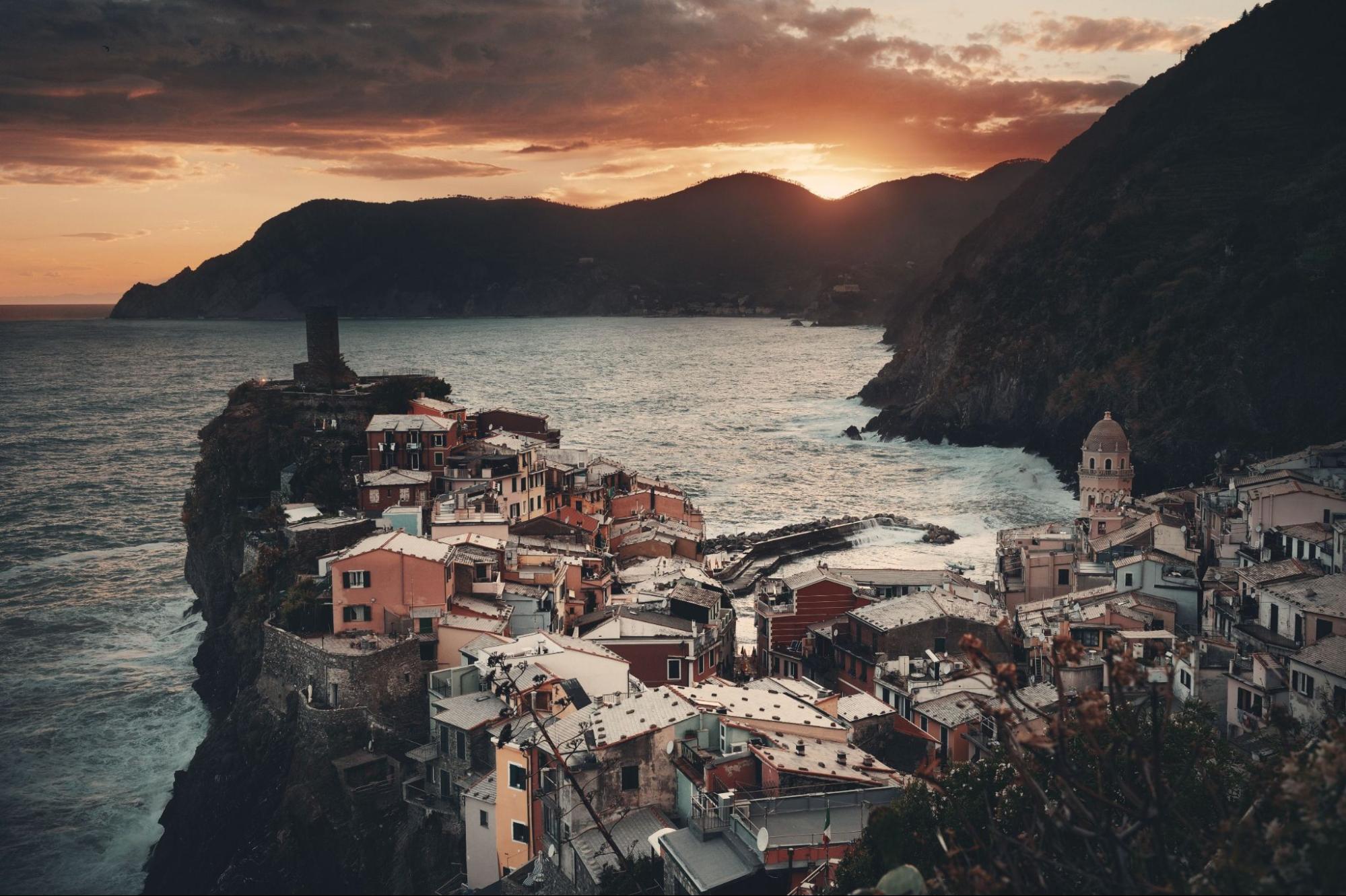 Colorful sunset in Vernazza with buildings on rocks over sea in Cinque Terre, Italy