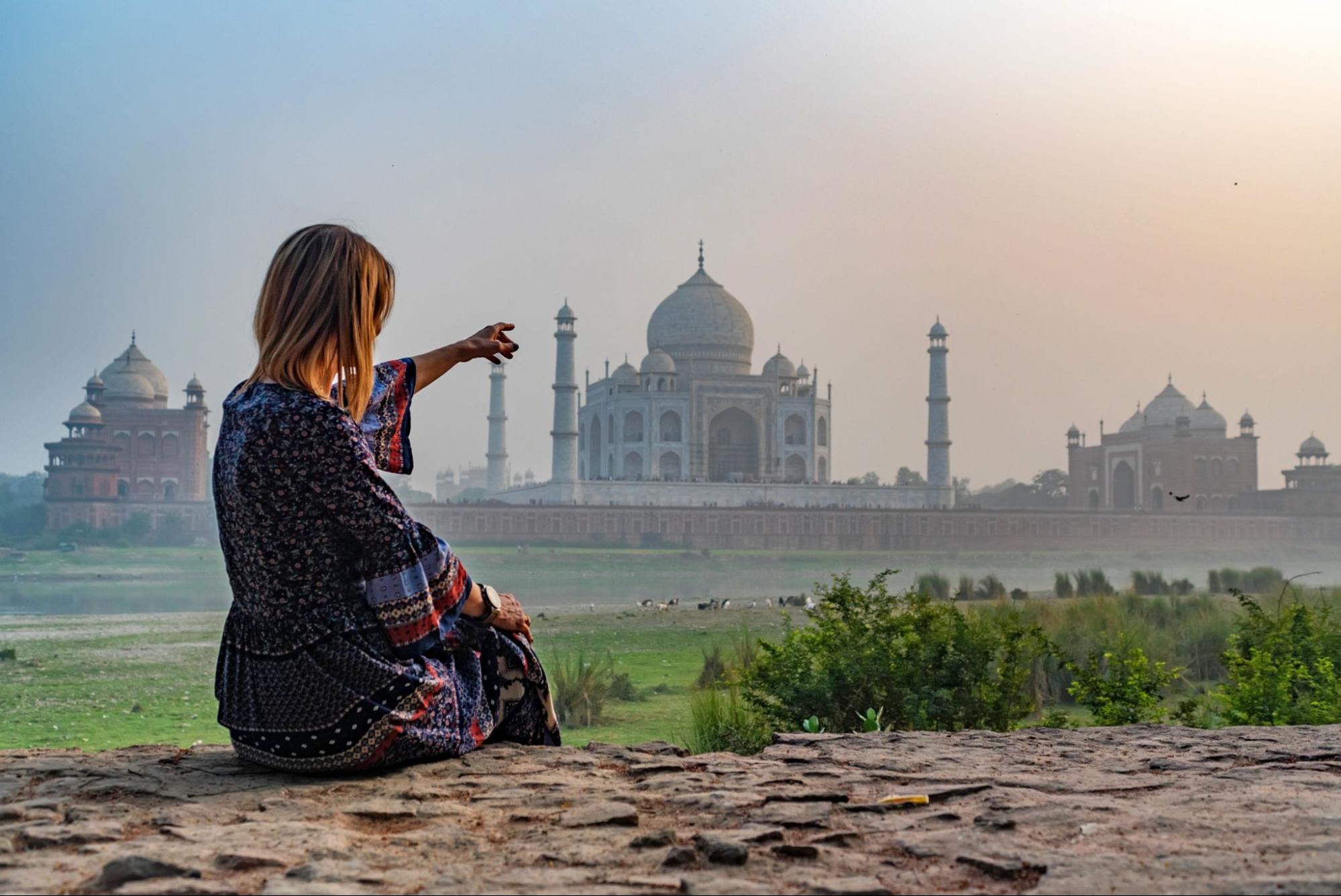 Beautiful girl points to Taj Mahal